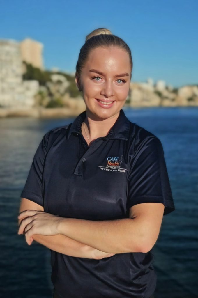 Female physiotherapist smiling outdoors wearing a Care 4 Health Osteopathy uniform
